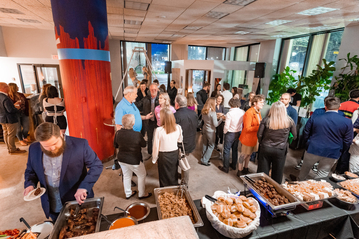 Overhead photo of partygoers mingling near the snack table